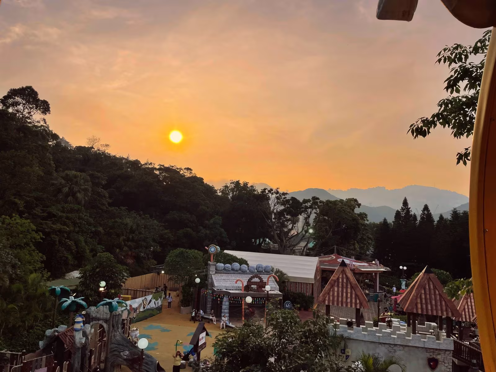 夕陽餘暉灑落在山林與建築間,遊客正在悠閒參觀。