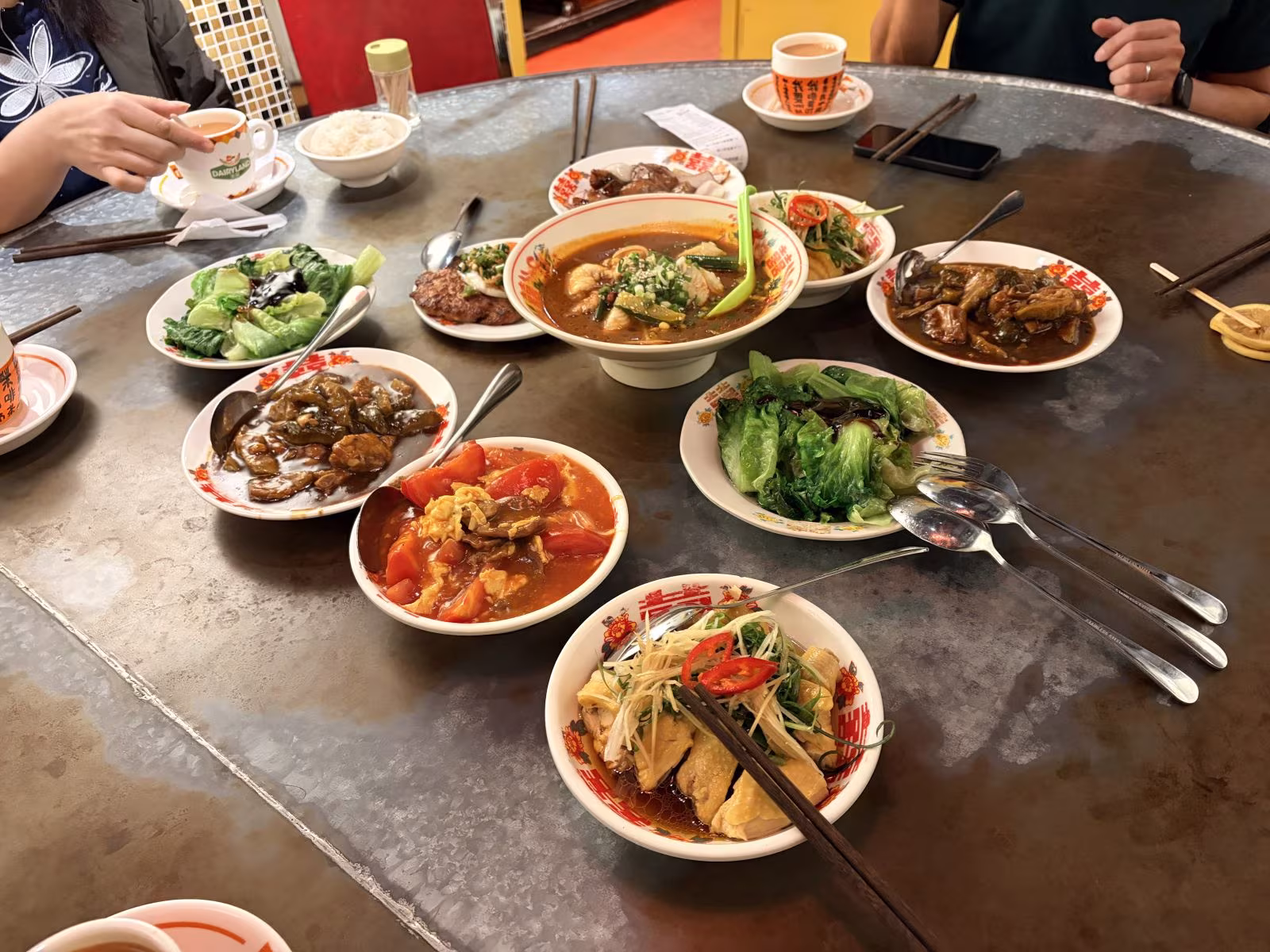 圓桌圍滿各色小菜,筷子與手影交織,熱鬧中藏著朋友間最真摯的分享與喜悅